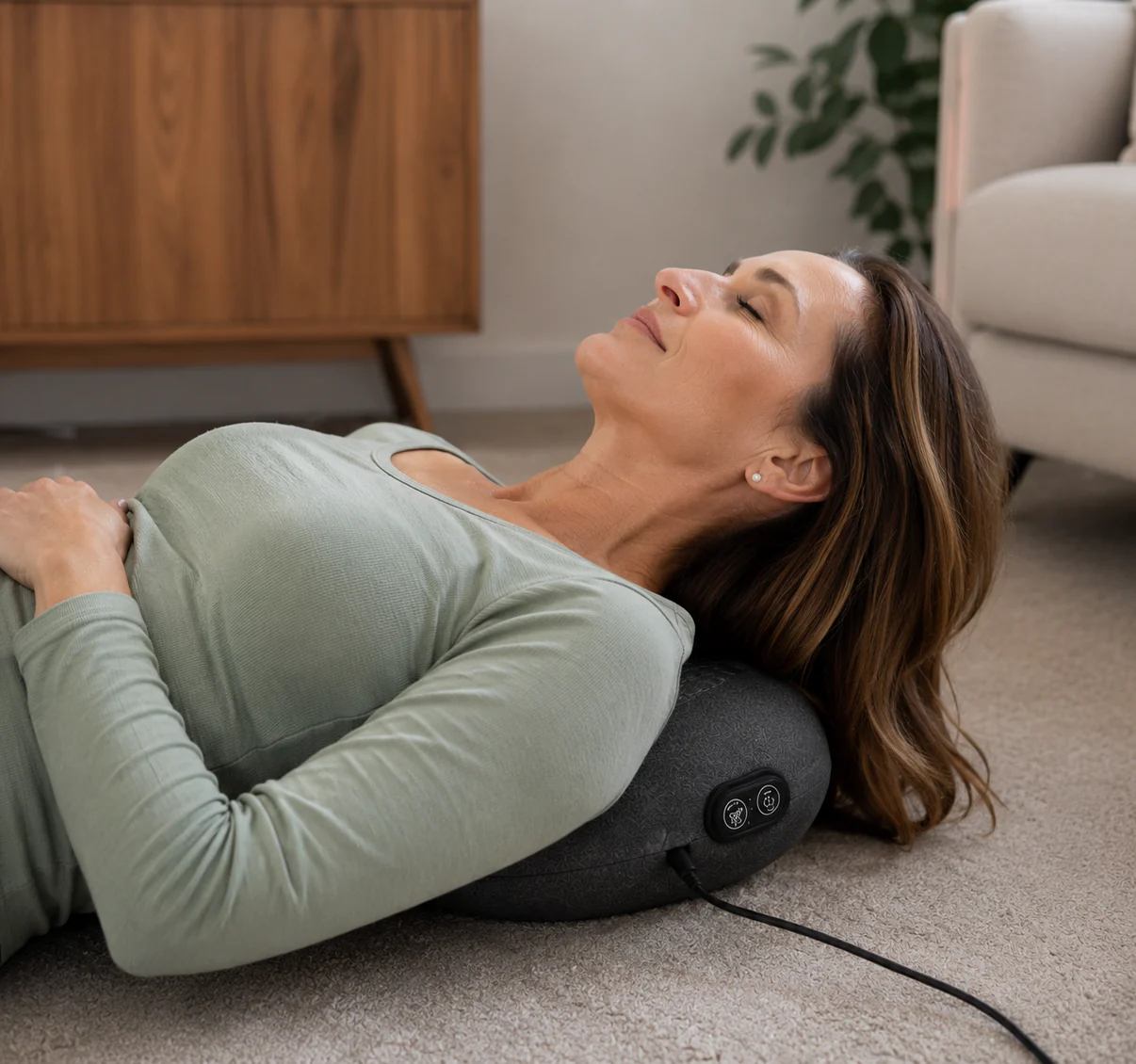 Adult relaxing on a sofa using the Orevive SpineEase at-home back comfort device